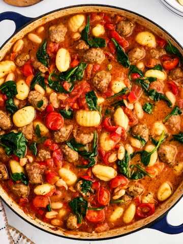 overhead view of tuscan white bean sausage gnocchi in dutch oven