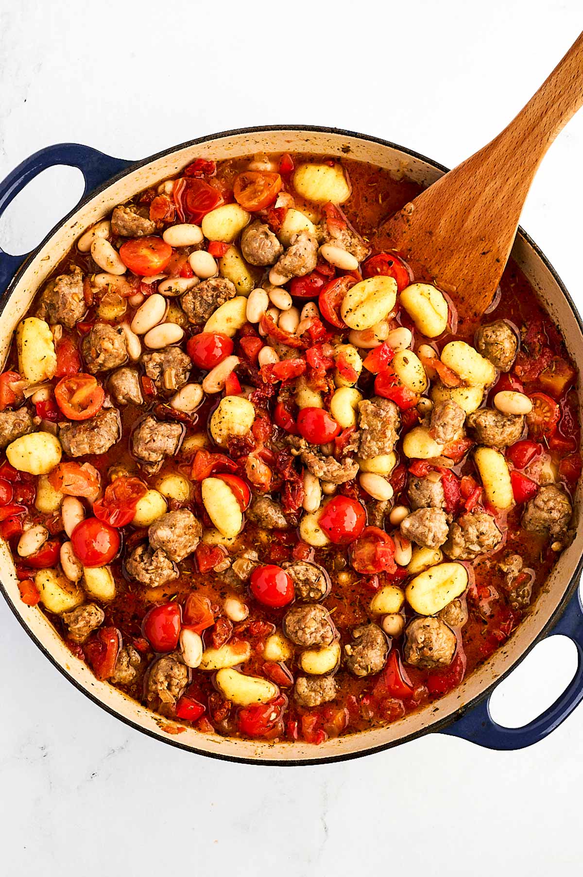 overhead view of unbaked tuscan sausage gnocchi in dutch oven