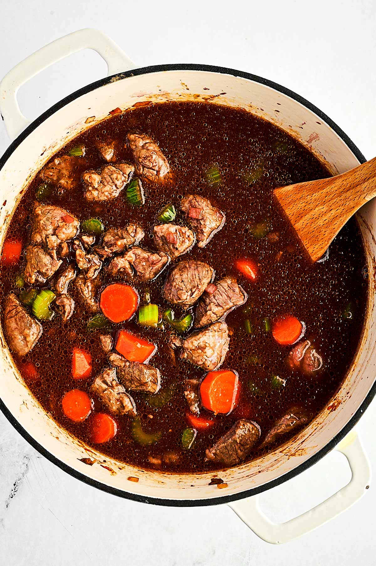 overhead view of beef, vegetables and gravy in Dutch oven