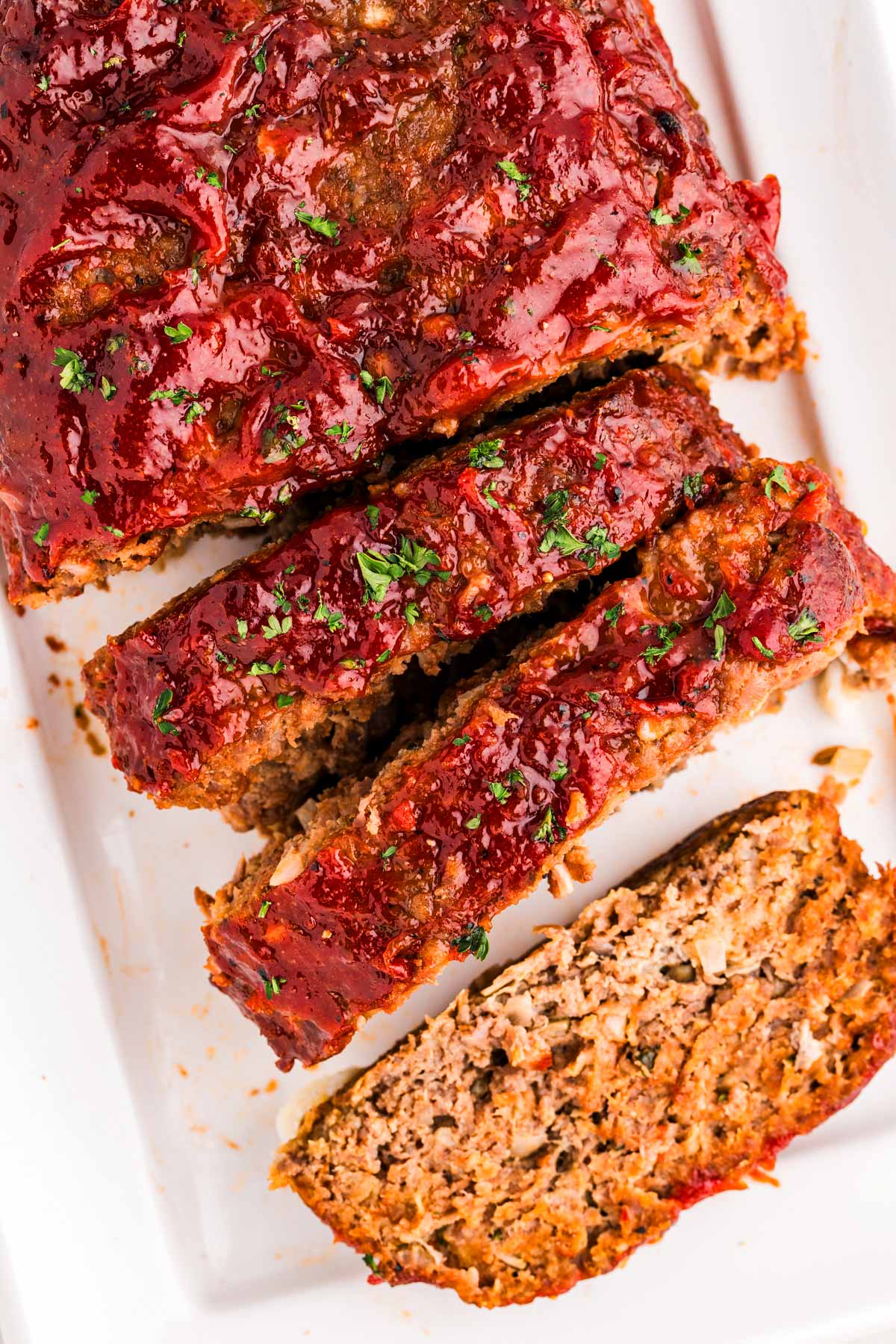 overhead view of several meatloaf slices on white platter