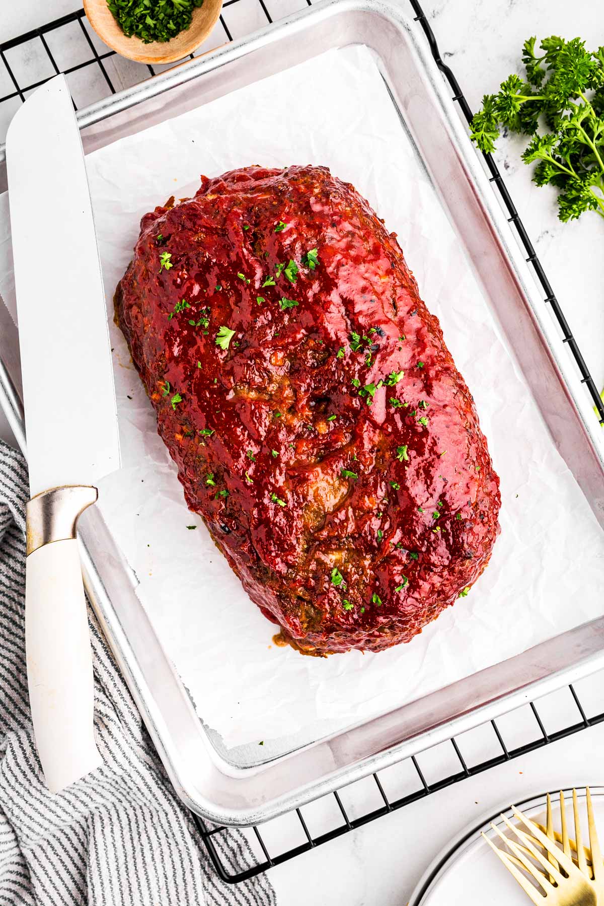 overhead view of meatloaf on lined baking sheet set on wire rack