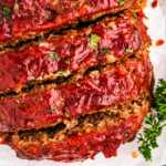 overhead view of sliced meatloaf on white platter