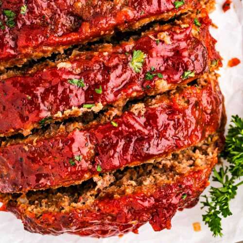 overhead view of sliced meatloaf on white platter