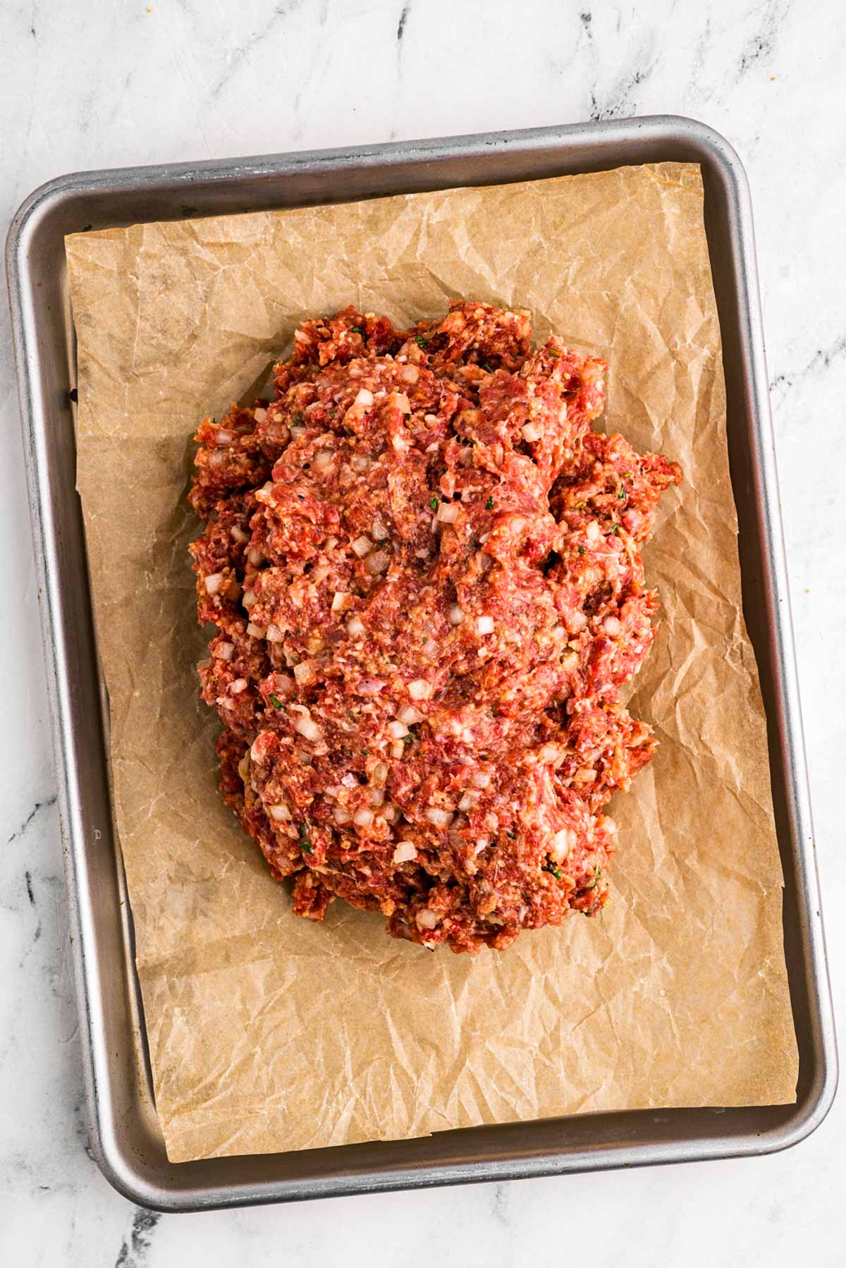 overhead view of meatloaf mixture on lined baking sheet