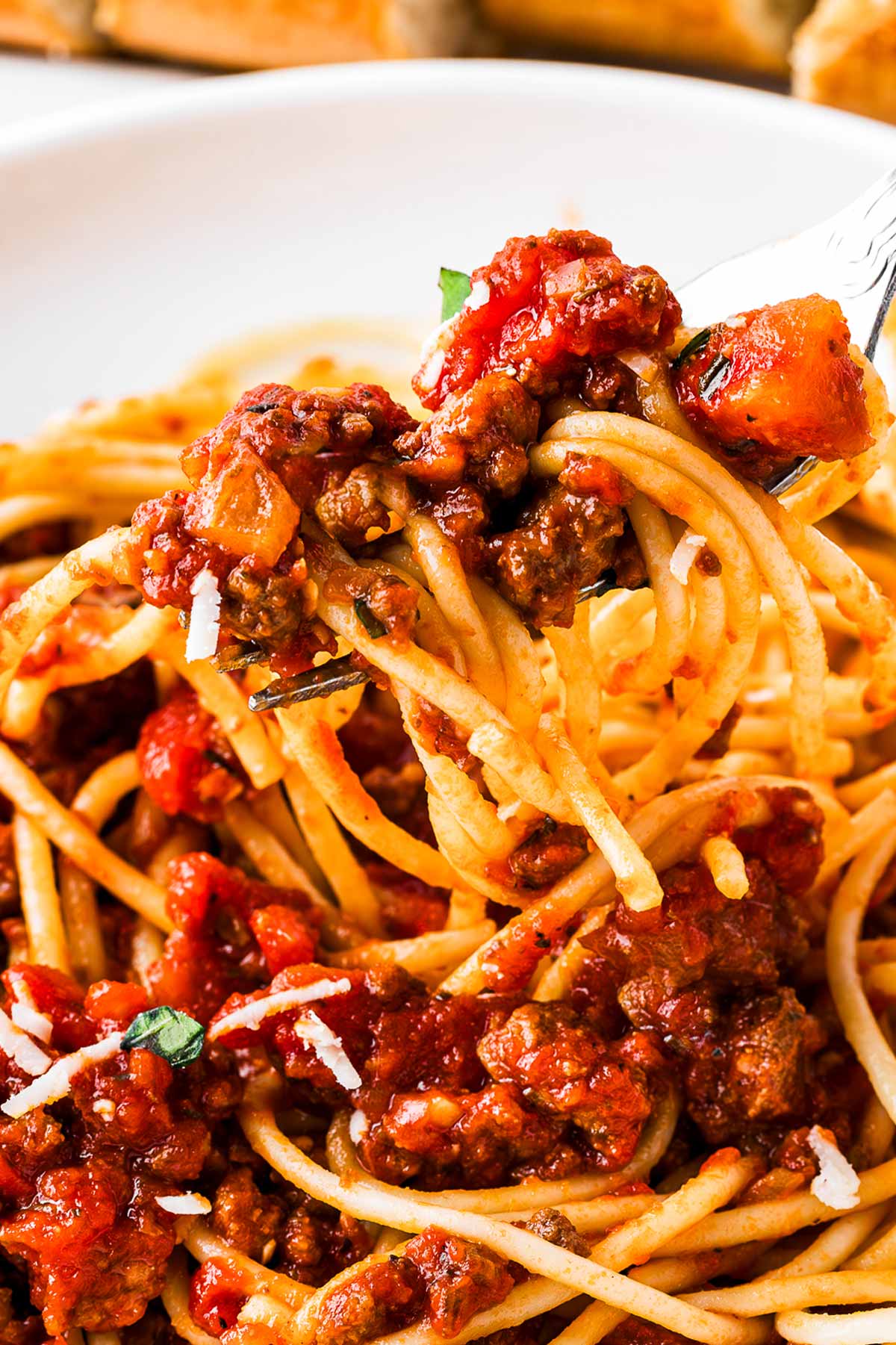 frontal close up view of spaghetti on fork with meat sauce