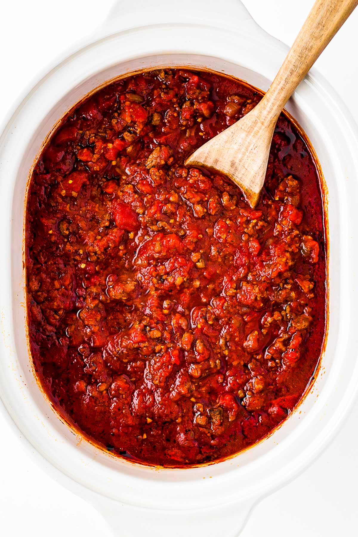 overhead view of uncooked spaghetti sauce in white slow cooker