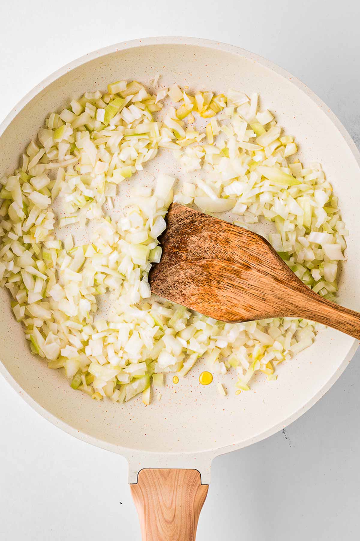 overhead view of chopped onions cooking in skillet