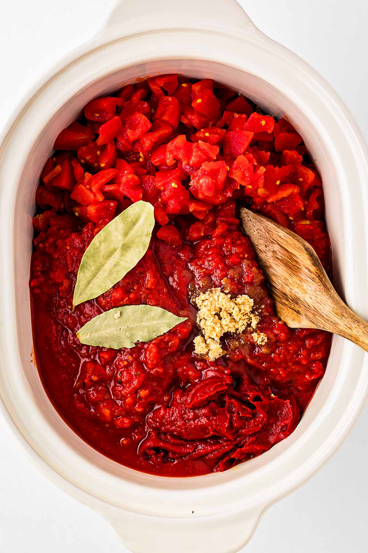 overhead view of uncooked spaghetti sauce in white slow cooker