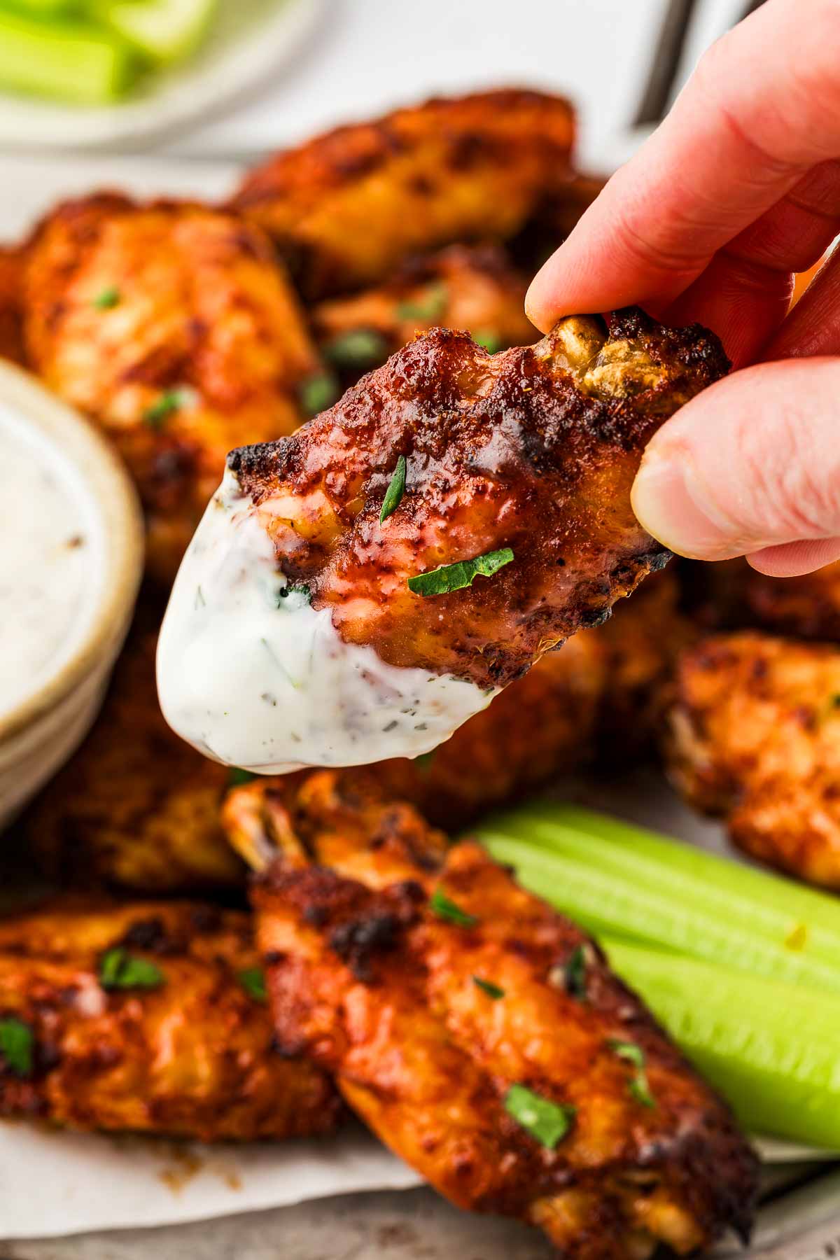 frontal view of crispy chicken wing dipped in ranch