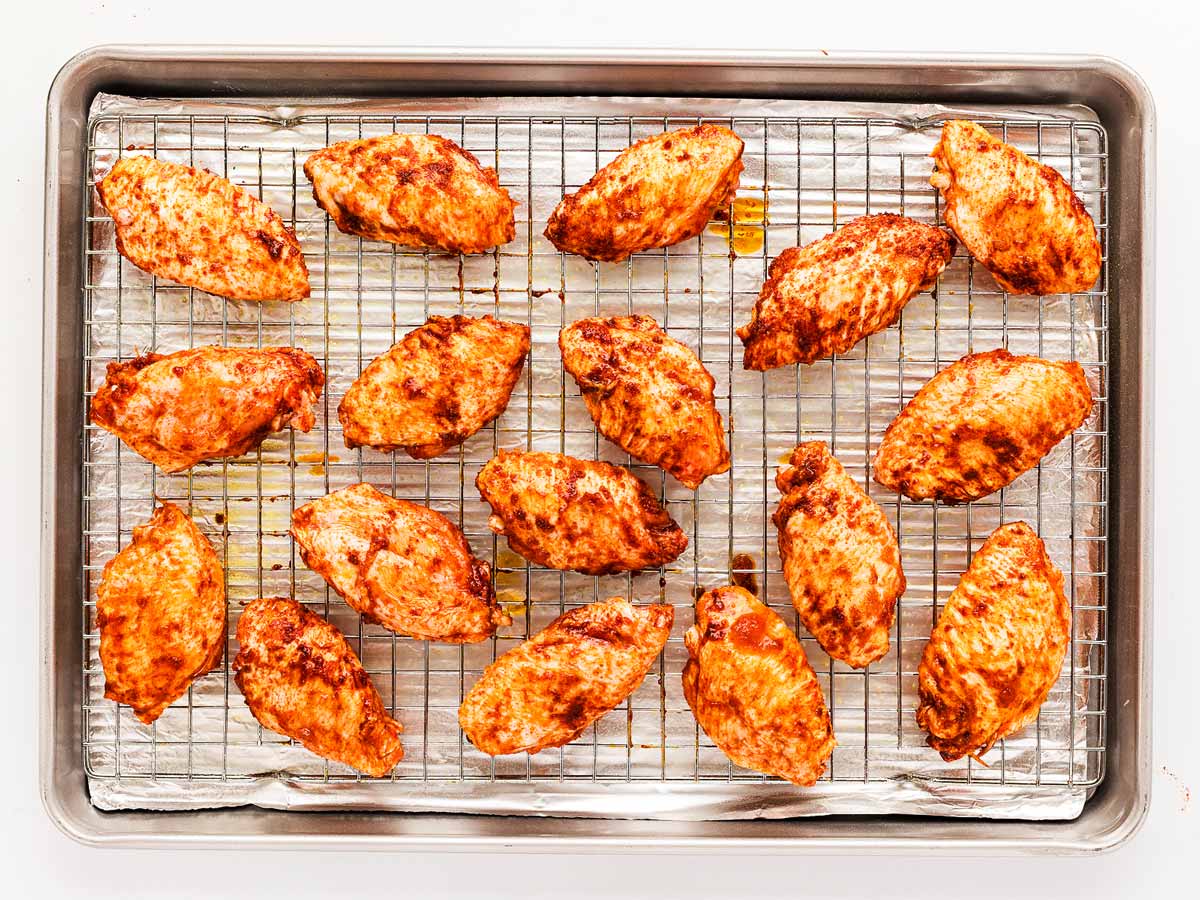 overhead view of seasoned chicken wings arranged in single layer on wire rack