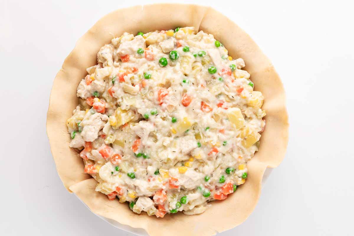 overhead shot of chicken filling in a pie crust-lined baking dish