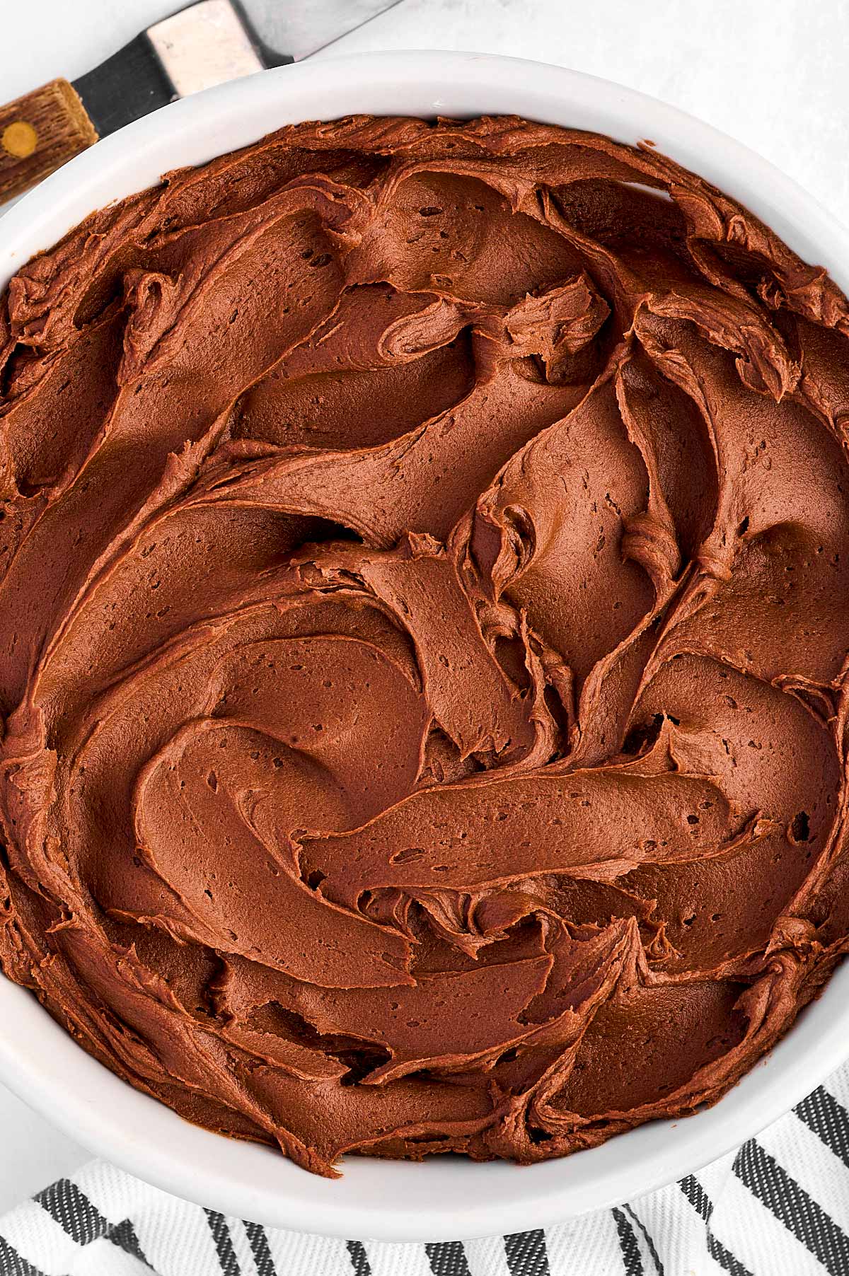 overhead view of chocolate buttercream frosting in white bowl