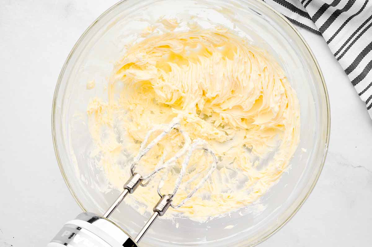 overhead view of beaten butter in glass bowl