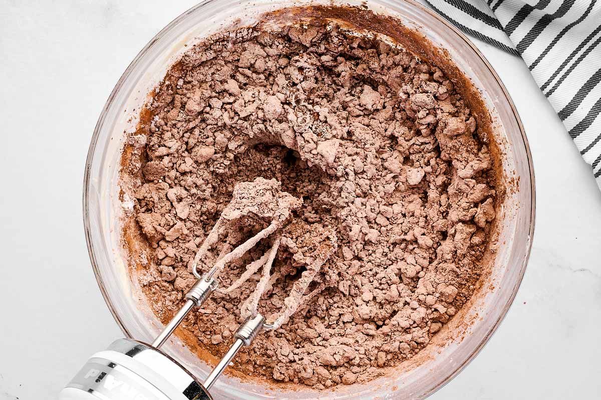 overhead view of chocolate buttercream ingredients in glass bowl