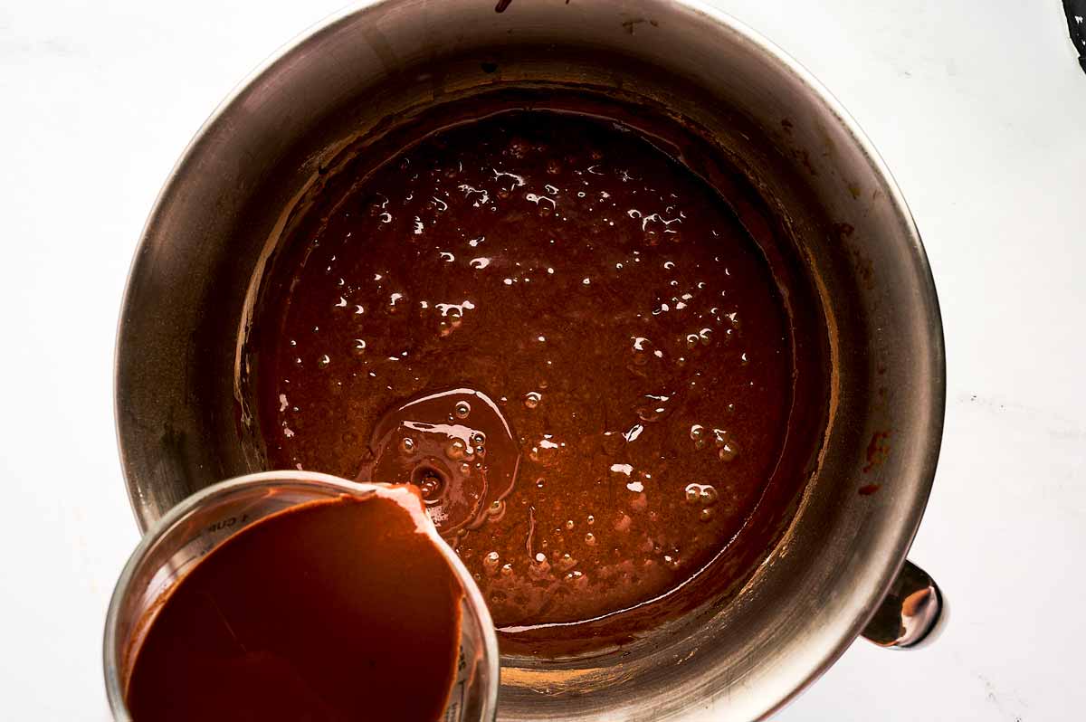 pouring hot coffee into bowl with chocolate cake batter