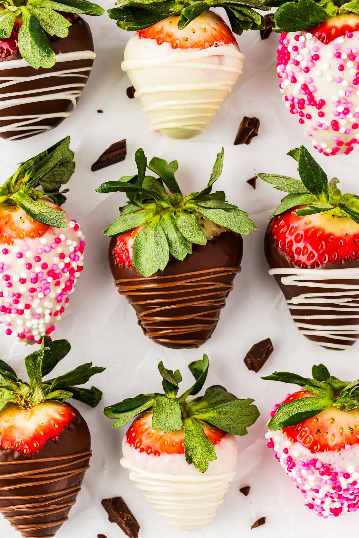 overhead view of several chocolate covered strawberries next to each other on white surface