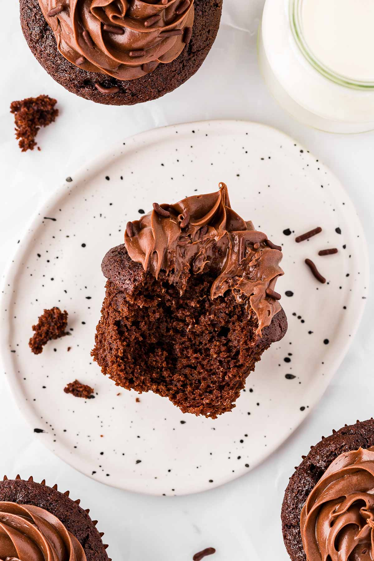 overhead view of chocolate cupcake on plate with bite taken out