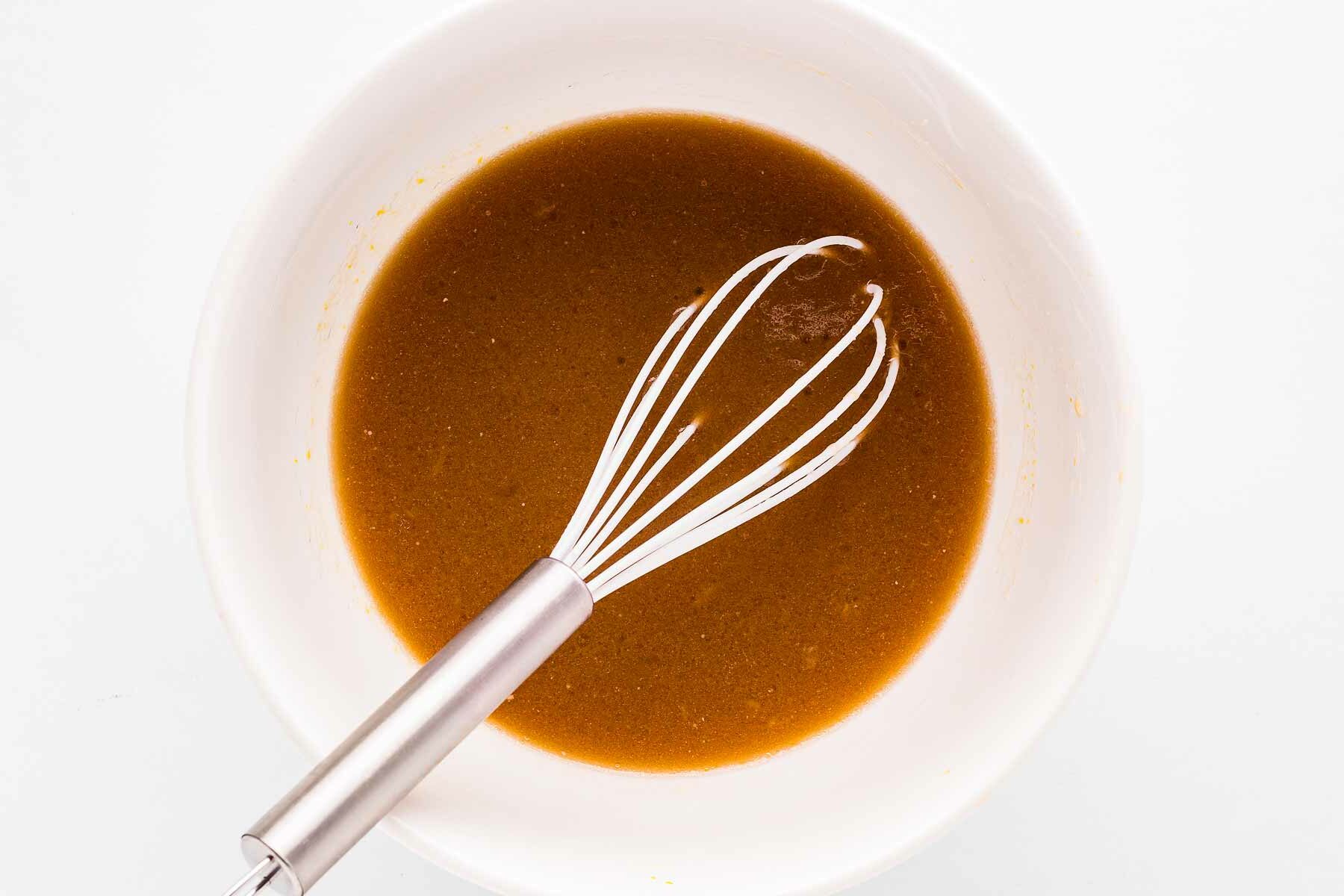 overhead view of wet chocolate cupcake ingredients in bowl after combining