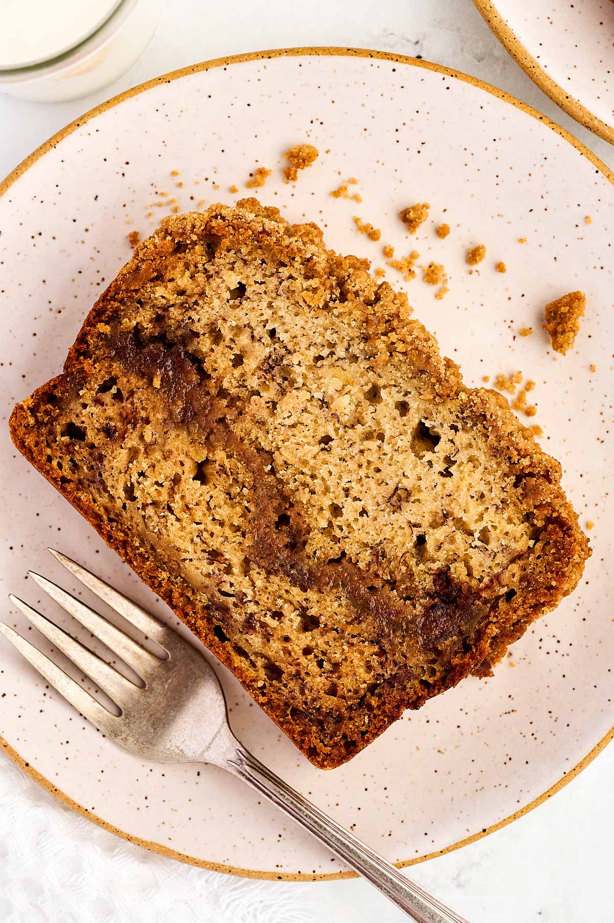 overhead view of slice of cinnamon banana bread on white plate