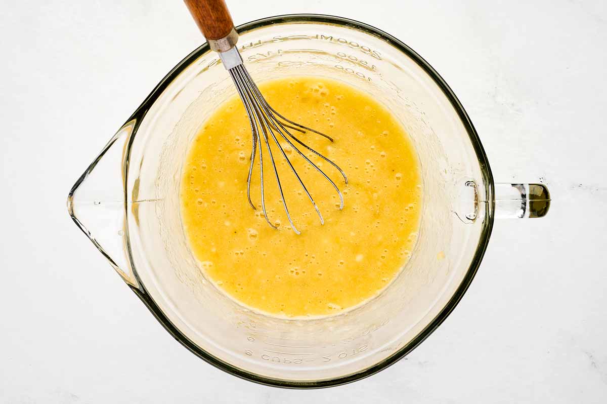 overhead view of wet ingredients for banana bread in a glass bowl