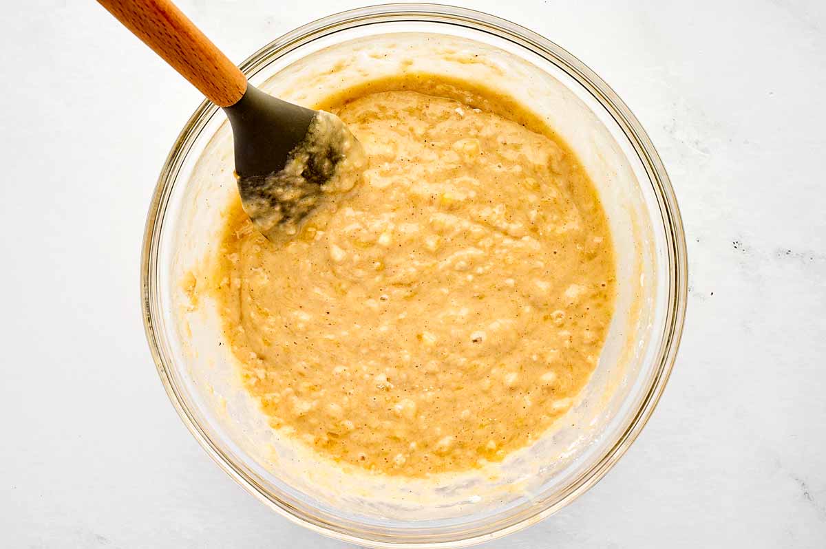 overhead view of banana bread batter in glass bowl