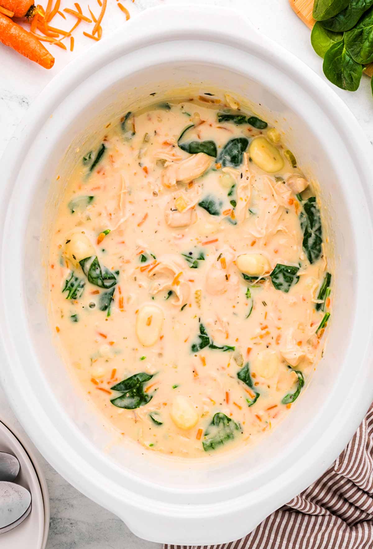 overhead view of chicken gnocchi soup in white crockpot