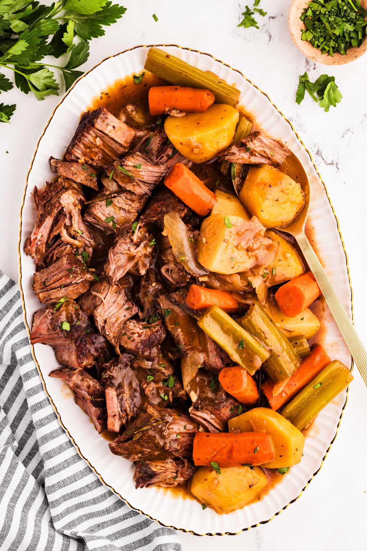 overhead view of pot roast on platter with carrots and potatoes