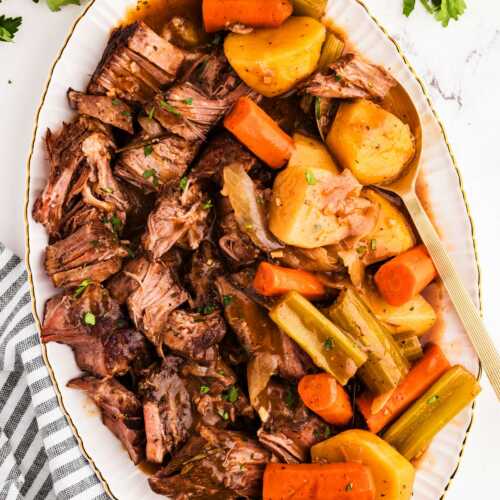 overhead view of pot roast on platter with carrots and potatoes