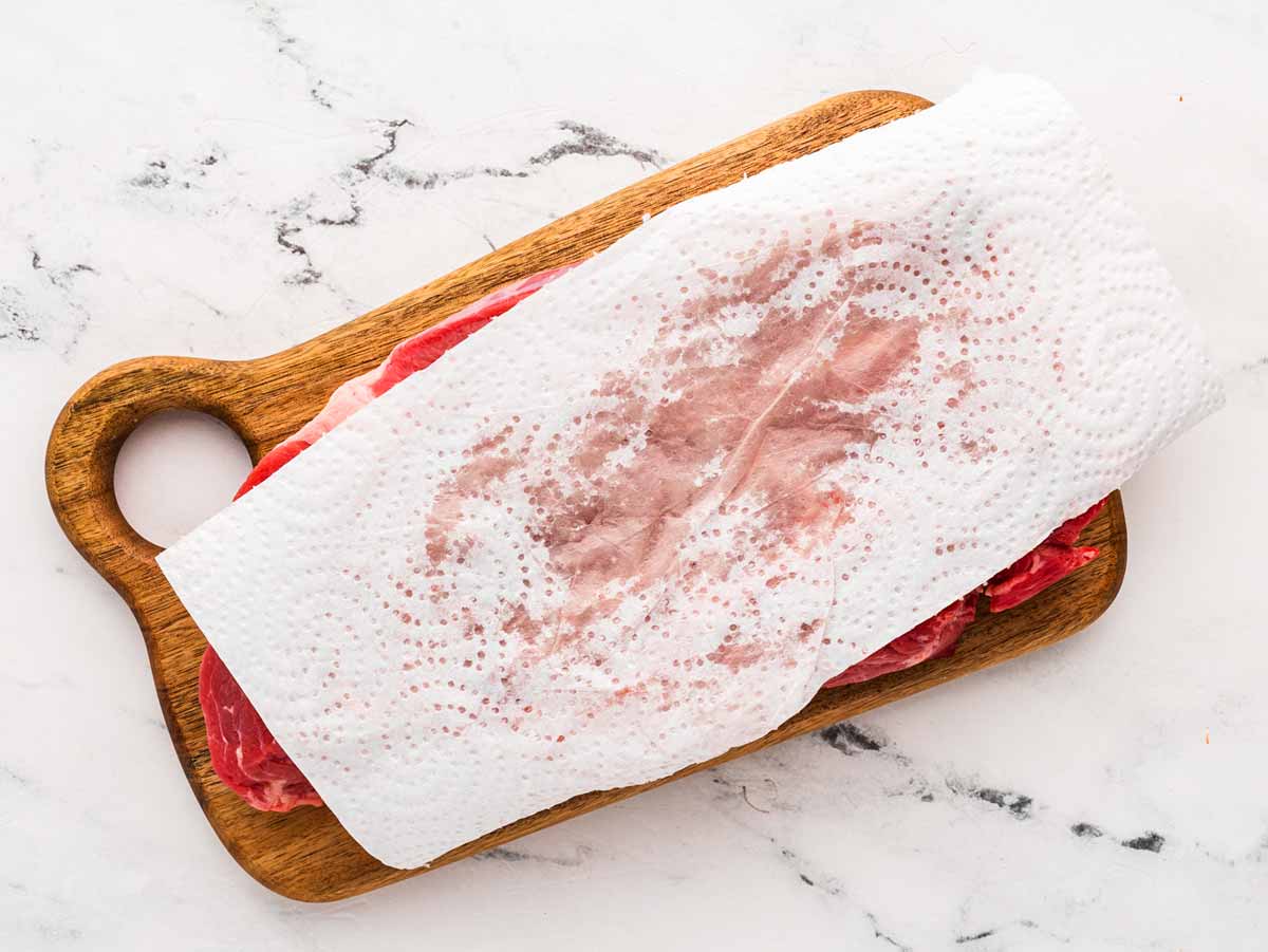 overhead view of chuck roast on cutting board with paper towel