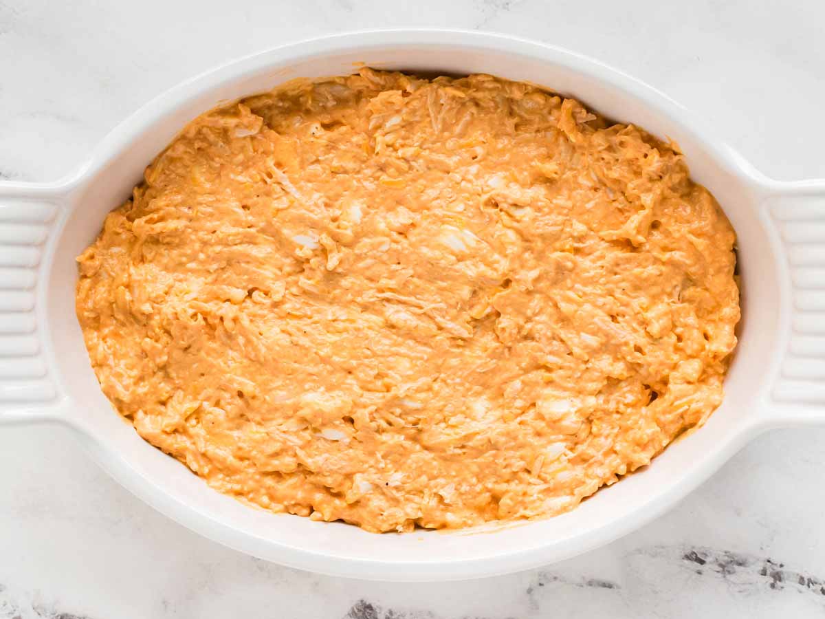 overhead view of unbaked buffalo chicken dip in white dish