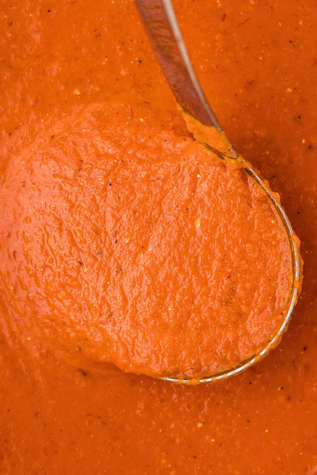 overhead view of ladle with tomato soup