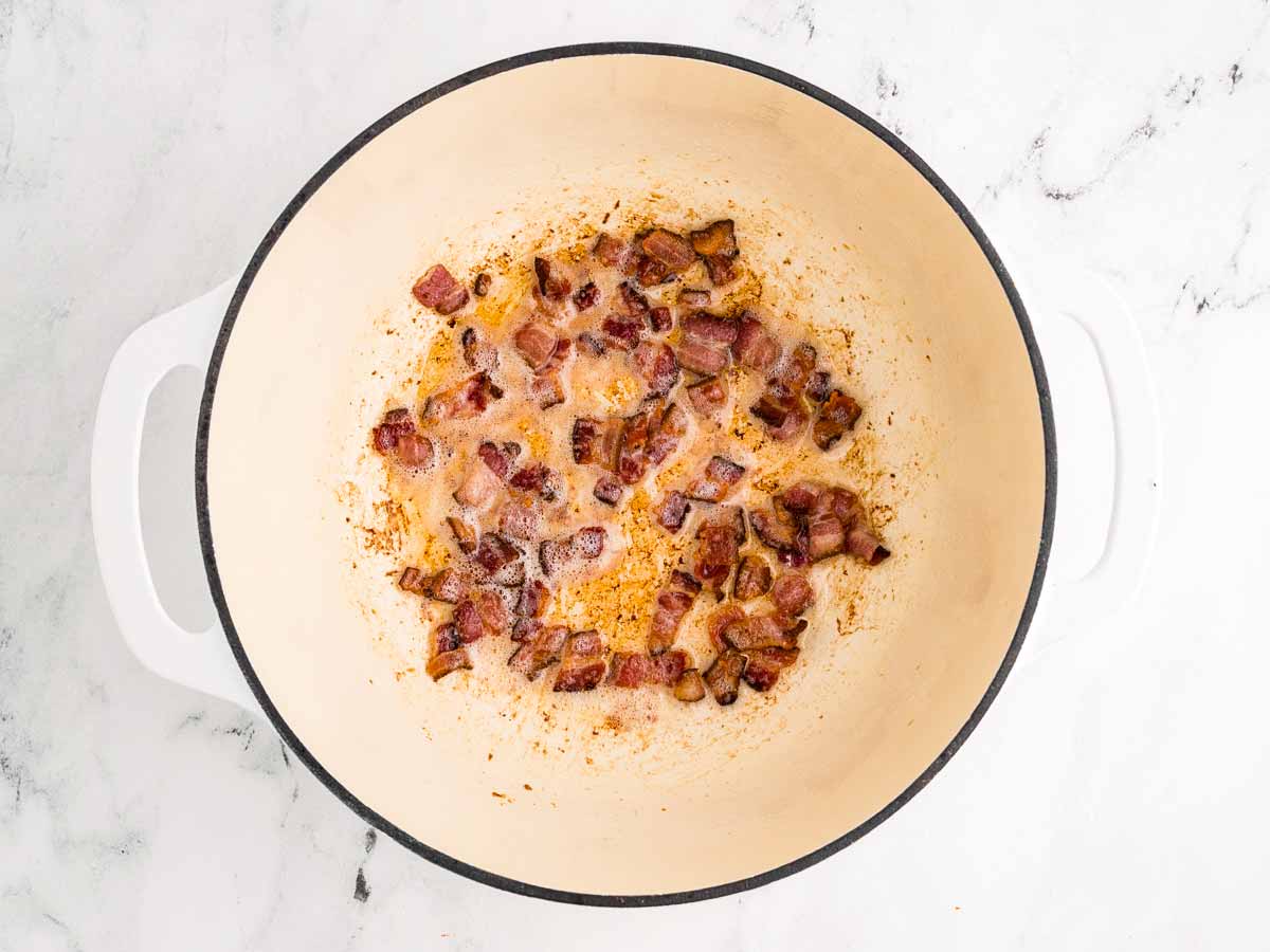 overhead view of crispy cooked bacon in a pot with rendered fat