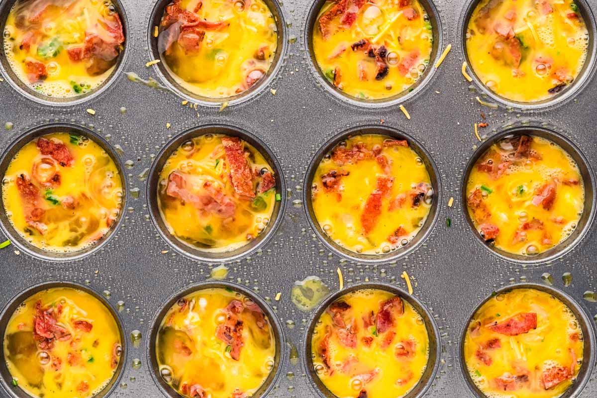 overhead view of unbaked egg bites in muffin pan