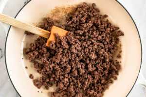 overhead view of browned ground beef in white skillet