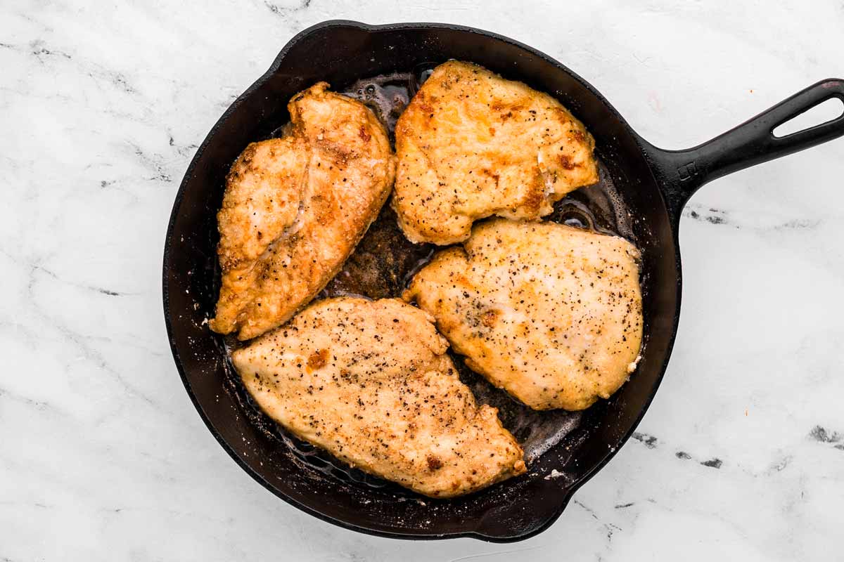 overhead view of cooked chicken in cast iron skillet