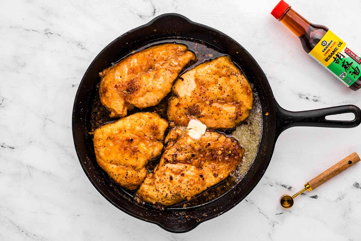 overhead view of chicken in skillet with honey garlic sauce