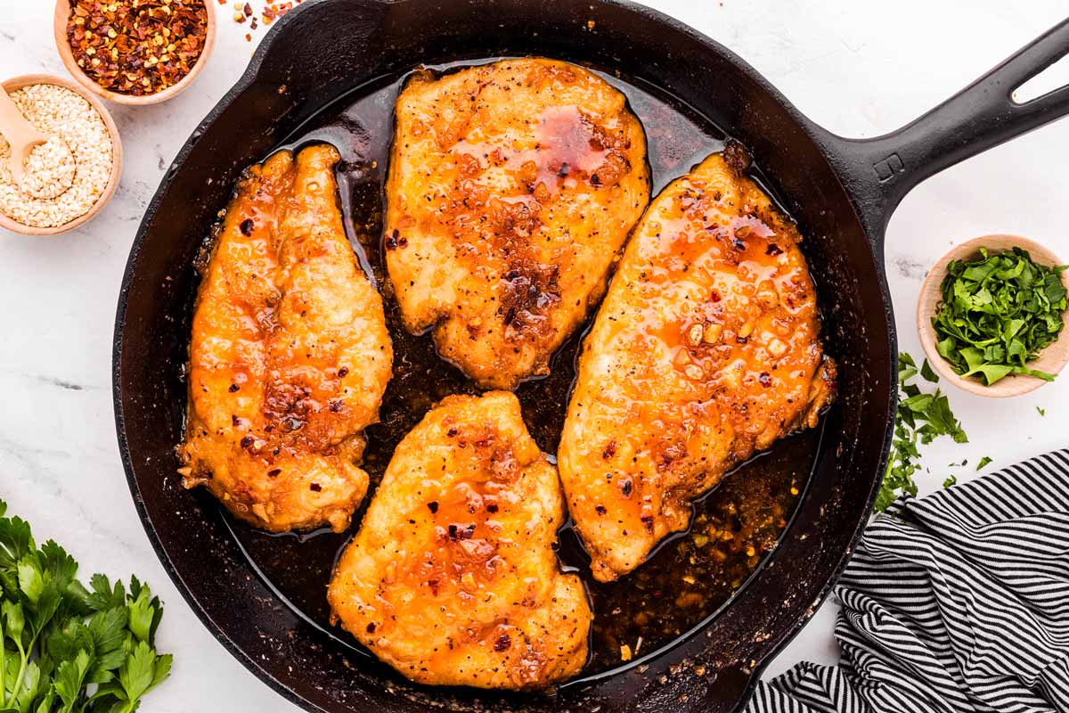 overhead view of finished one garlic chicken in cast iron skillet