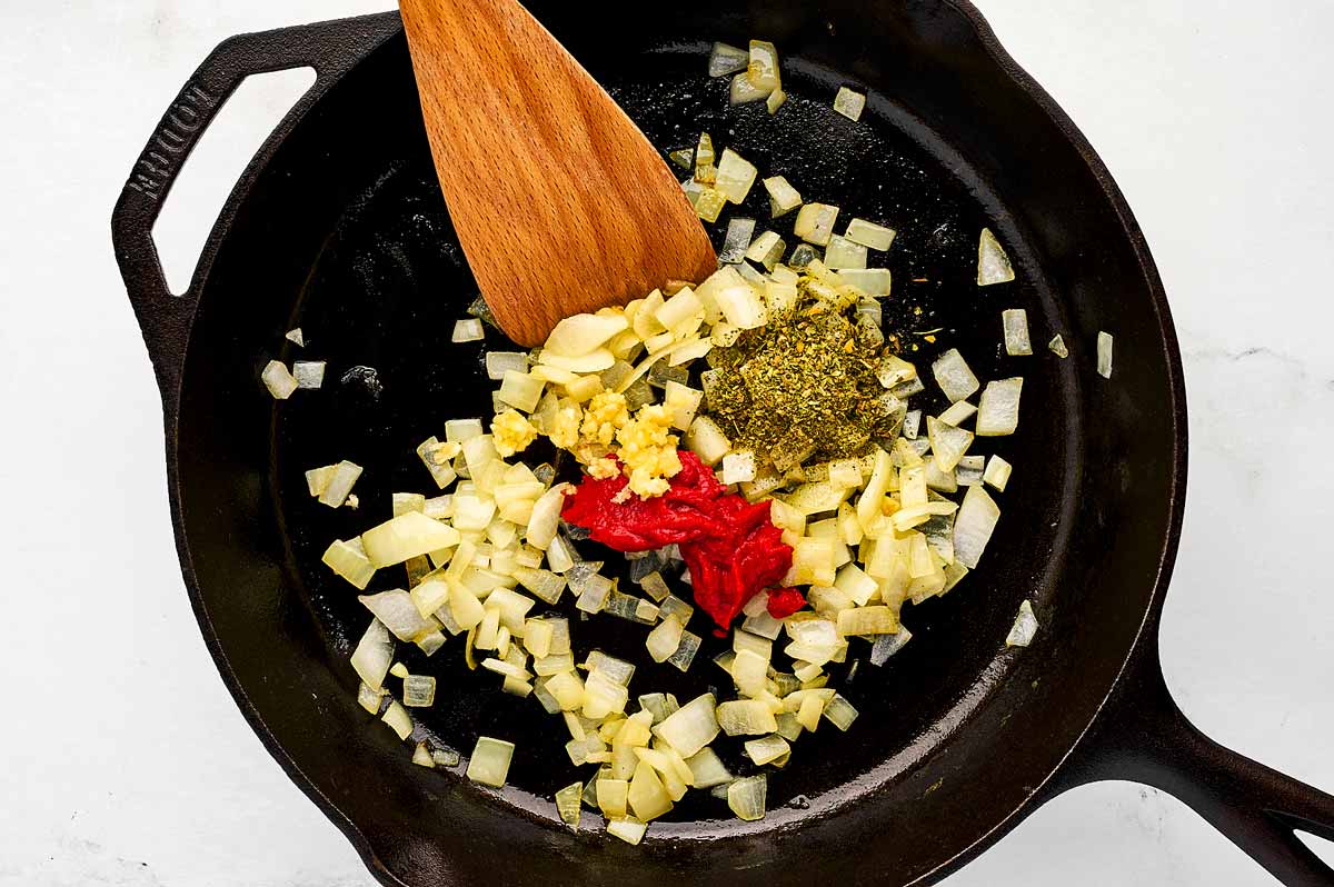 overhead view of sautéed onion in skillet with seasoning