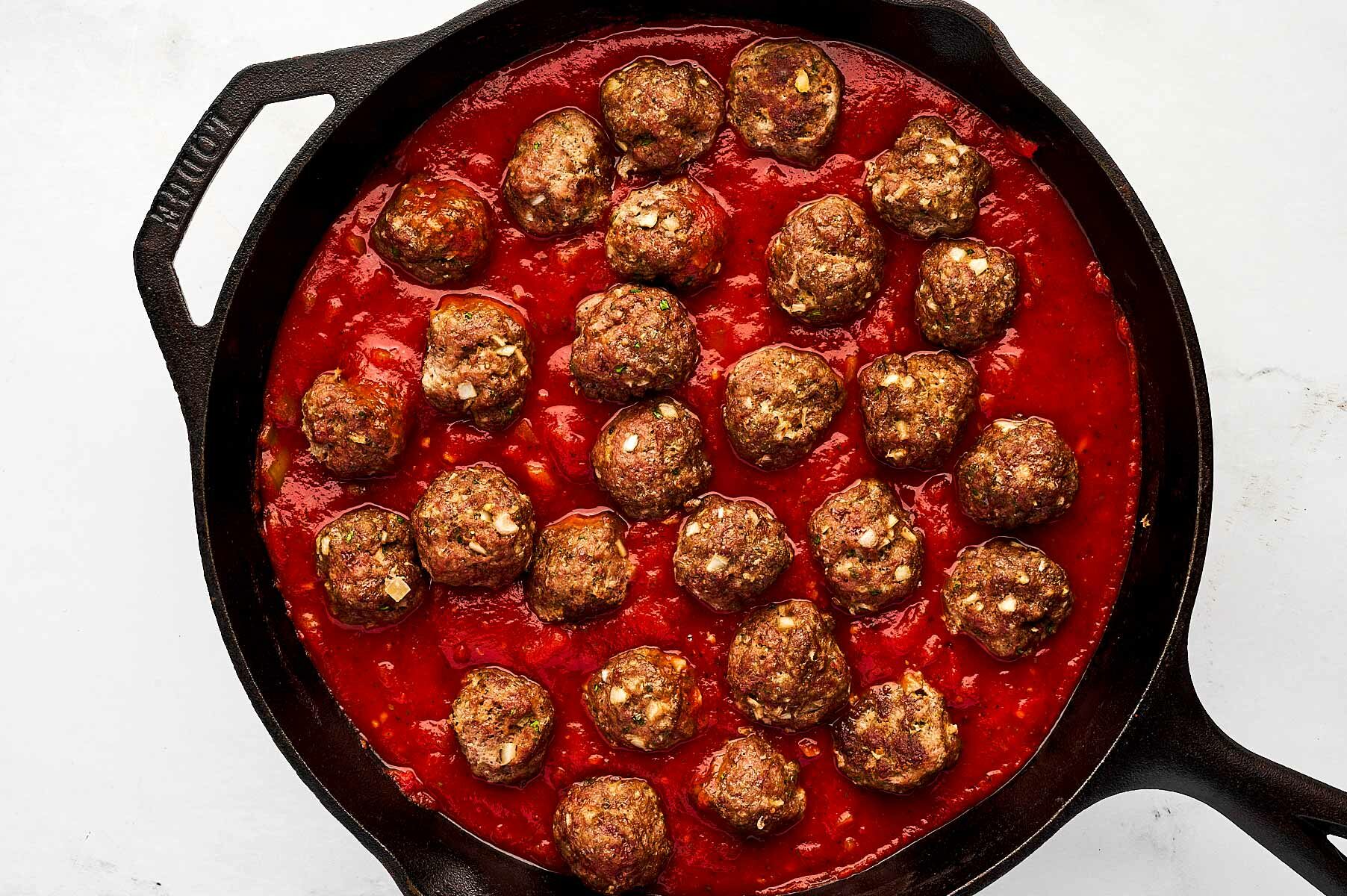 overhead view of meatballs in skillet with tomato sauce