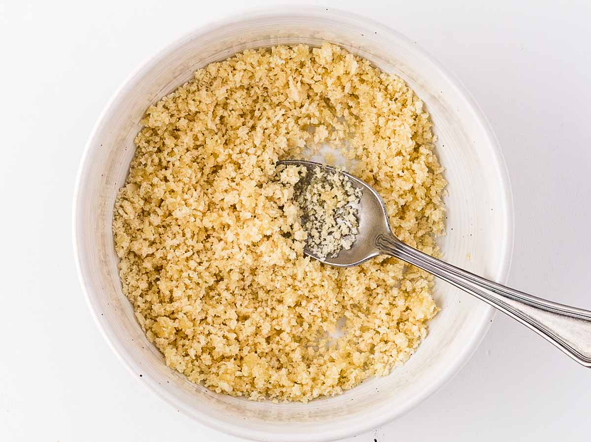 overhead view of panko breadcrumbs butter and bacon fat being mixed in a small bowl