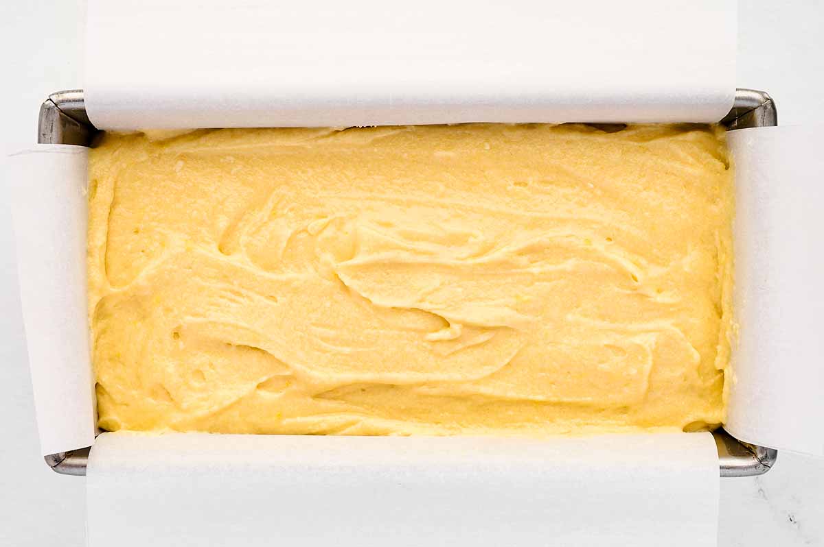 overhead view of lemon pound cake batter in lined loaf pan