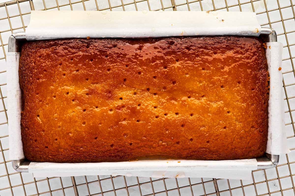 overhead view of syrup soaked lemon pound cake in lined loaf pan