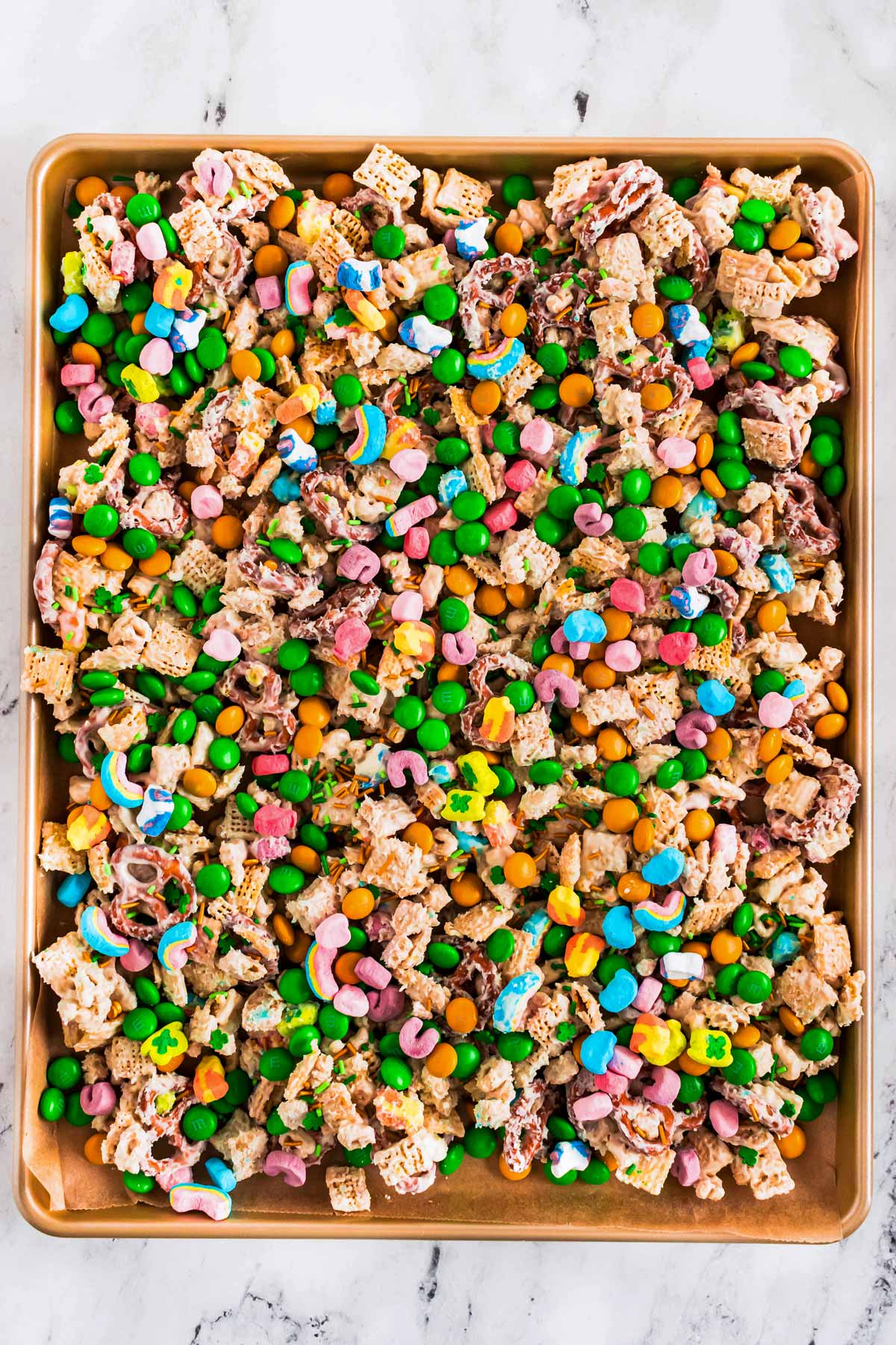 overhead view of leprechaun bait Chex mix on baking sheet with candy