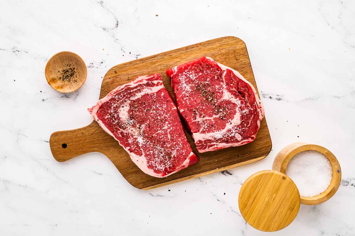 overhead view of seasoned steak on cutting board