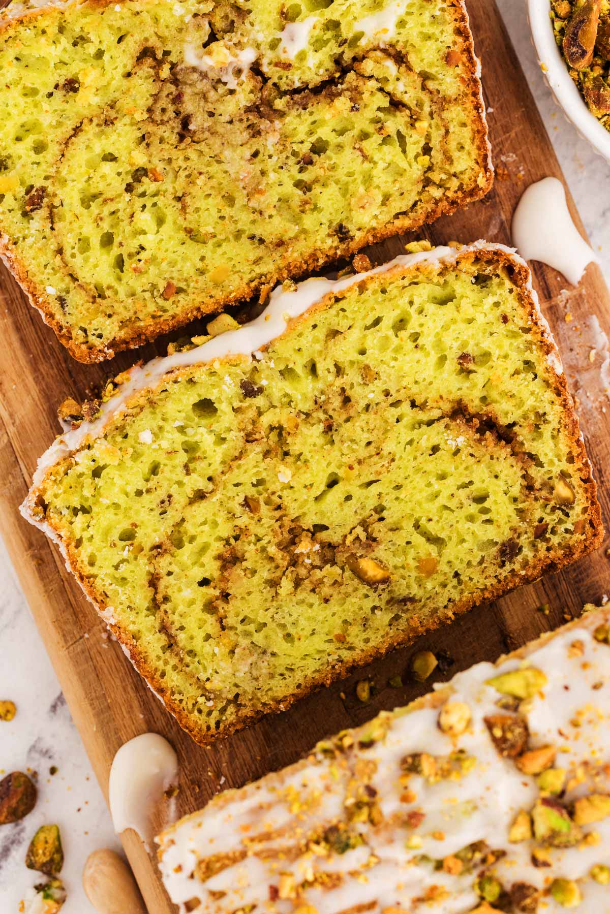 close-up of a slice of pistachio bread showing its soft texture and chopped pistachios