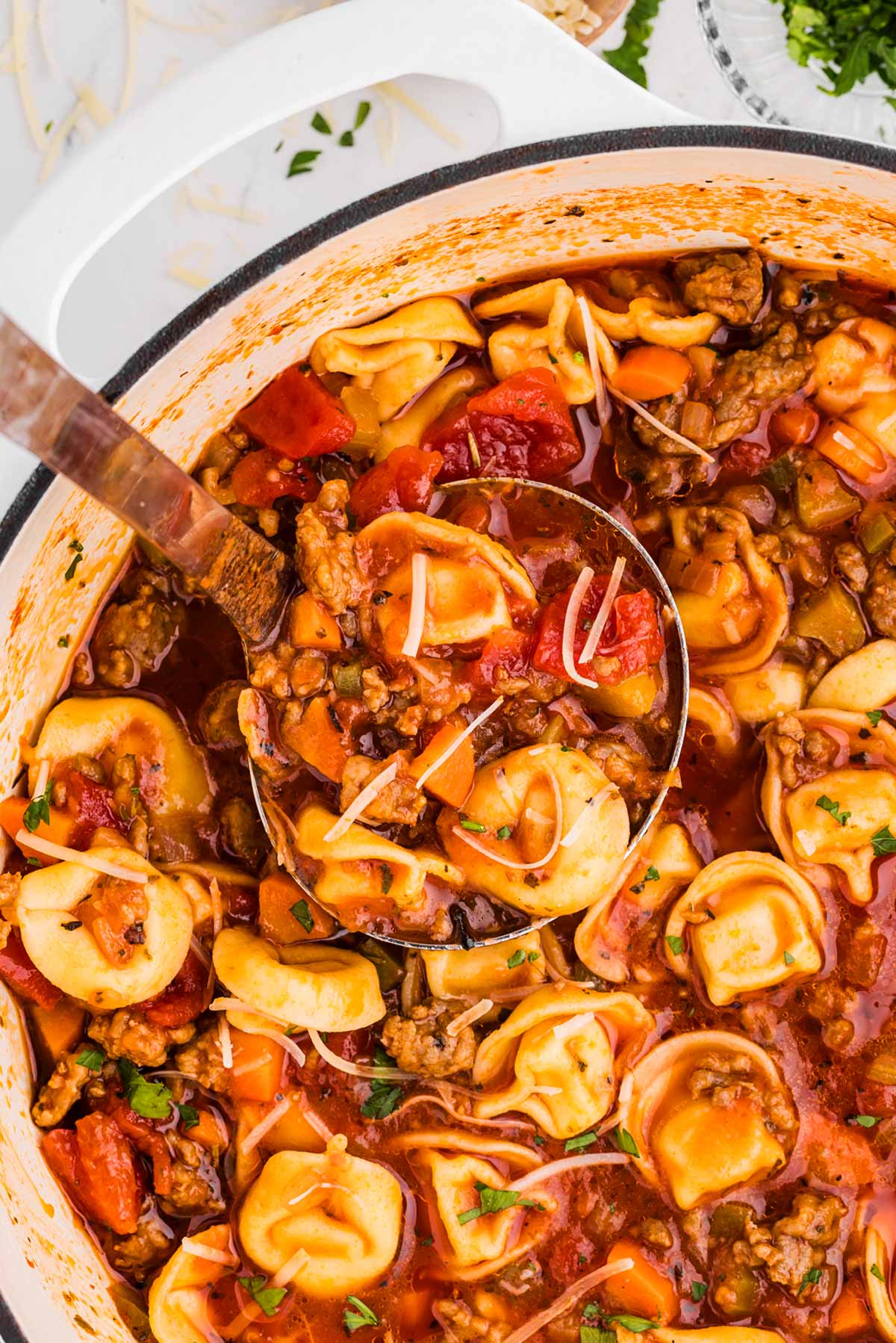 overhead view of ladle in tortellini soup