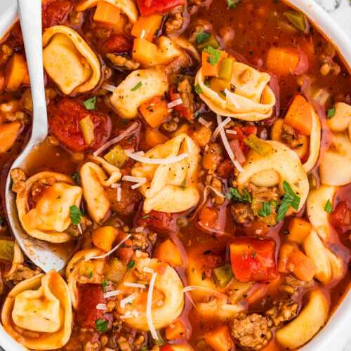 overhead view of sausage tortellini soup in white bowl