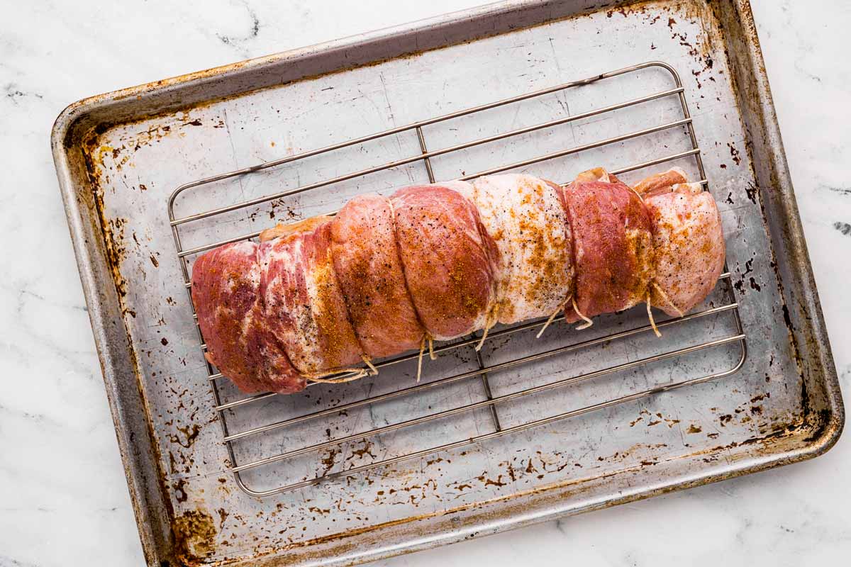 overhead view of pork loin roast rolled up and seasoned