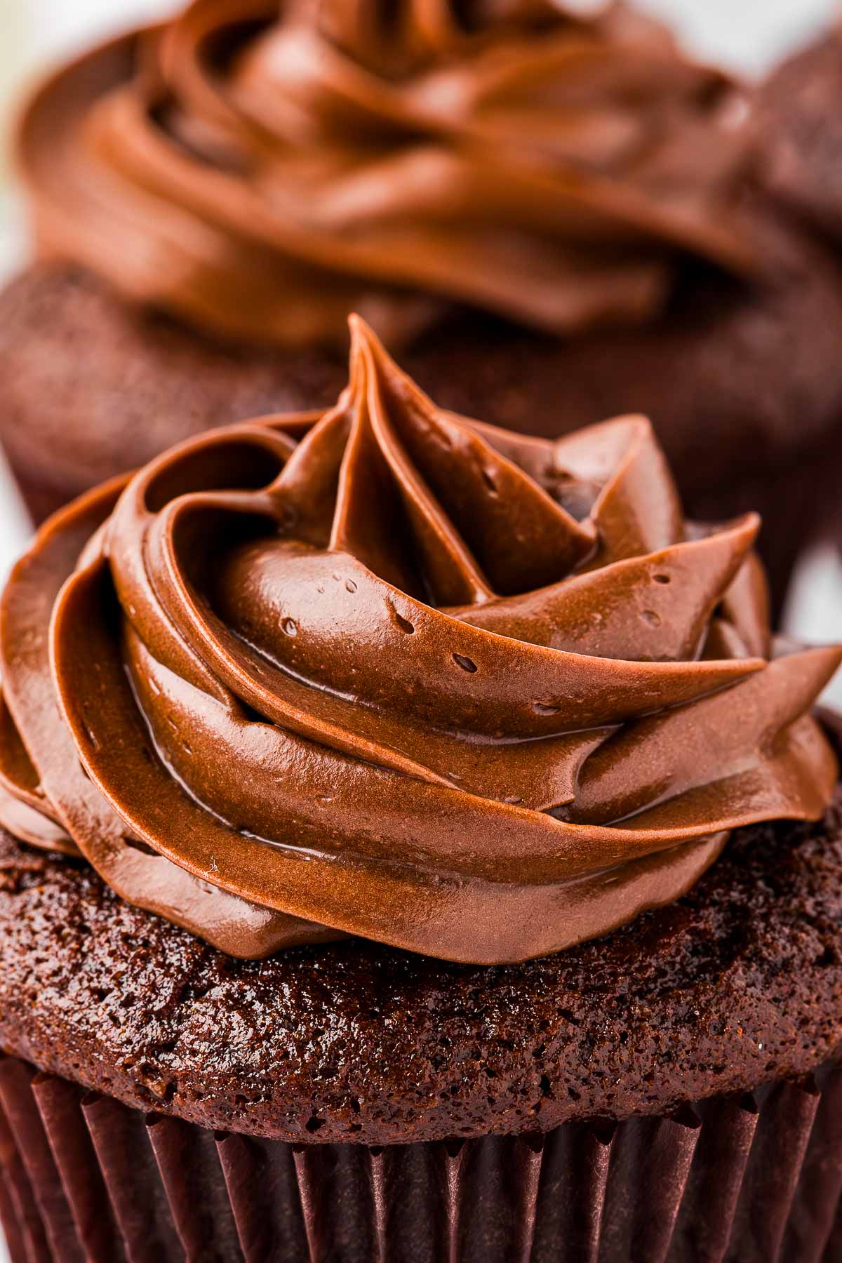 frontal close up view of whipped ganache on chocolate cupcake