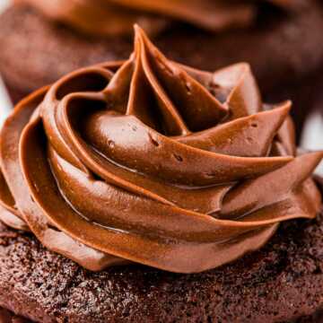 frontal close up view of whipped ganache on chocolate cupcake